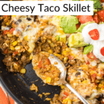 Cheesy taco skillet with toppings with one portion removed and a serving spoon in its place.