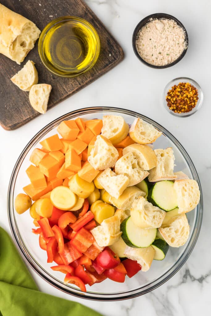 Vegetables and bread in a bowl for sheet pan sausage and veggie recipe.