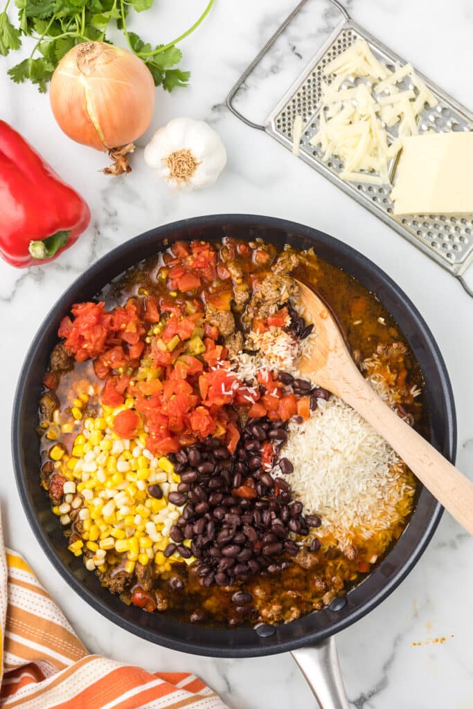 All the ingredients in a pan except the cheese to make One Pot Cheesy Taco Skillet.