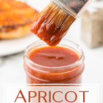 Apricot bbq sauce in a jar with a brush coming out of the jar.