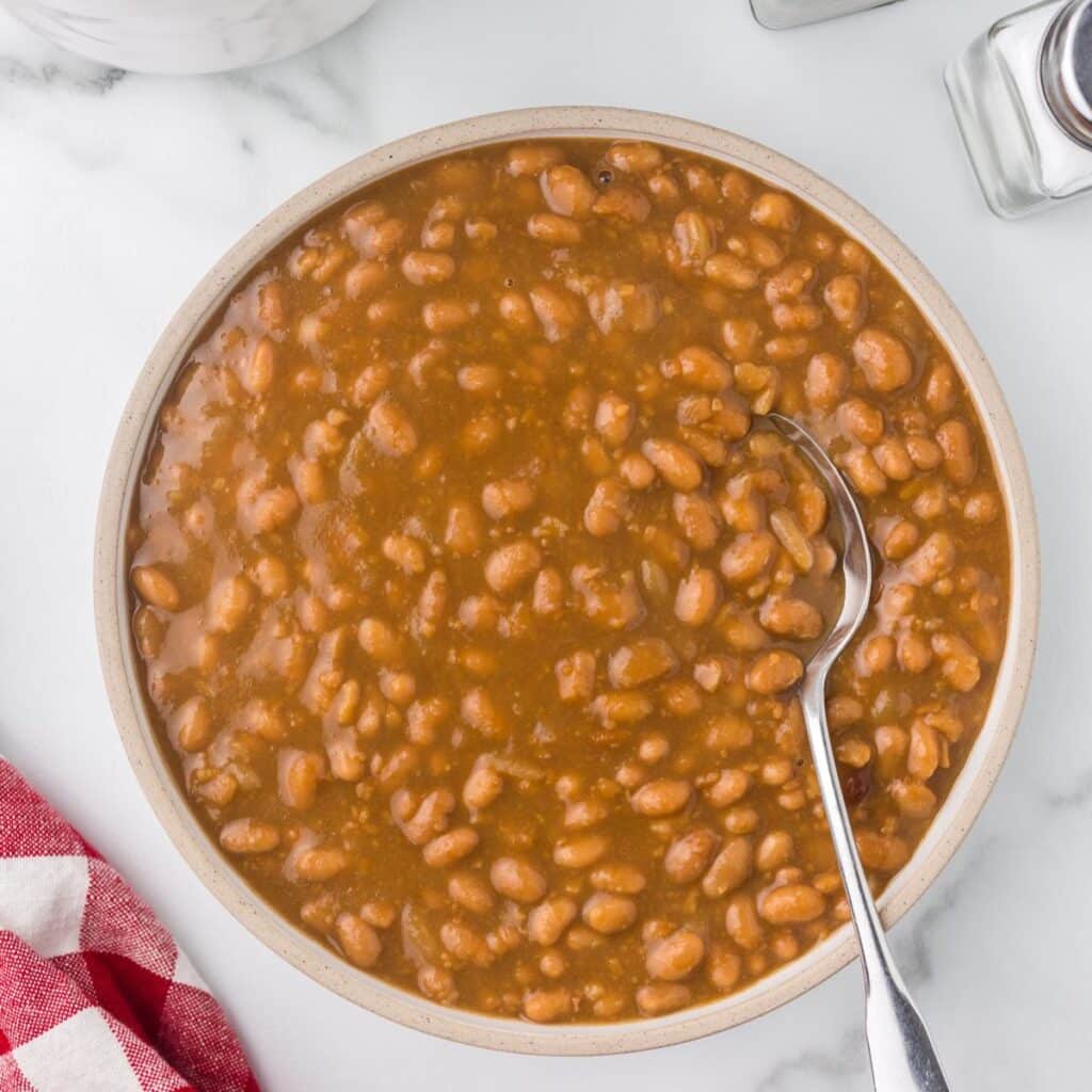 Baked beans in a bowl with a spoon.