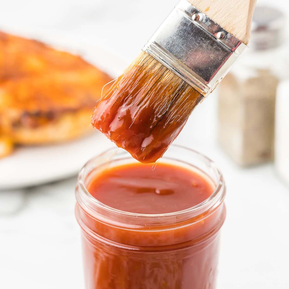 Apricot BBQ Sauce on a brush with grilled chicken.
