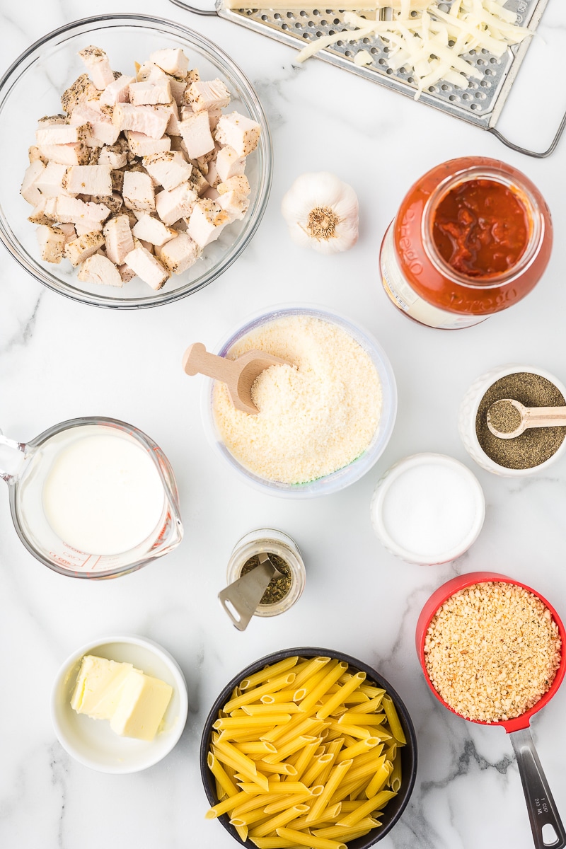 Ingredients to make baked chicken parmesan with penne pasta.