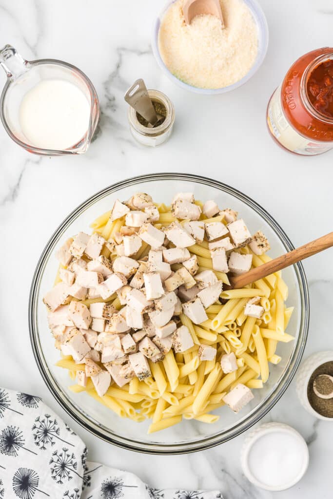 Pasta and chicken in a bowl to make parmesan chicken pasta.