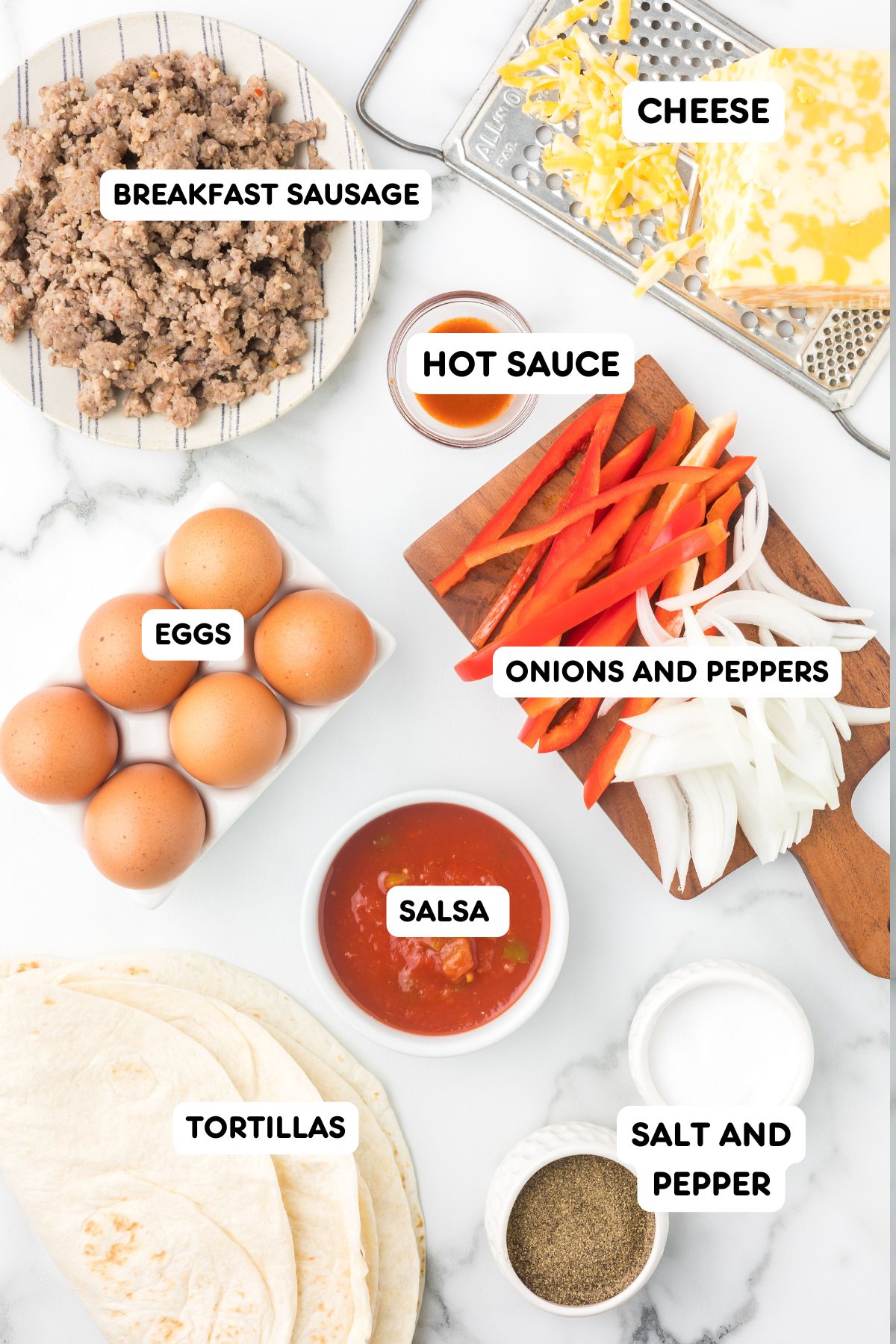 Ingredients to make breakfast burritos including tortillas, eggs, onions and peppers, sausage and cheese.
