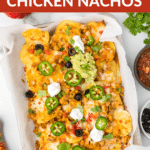 Chicken nachos on a sheet pan with toppings.