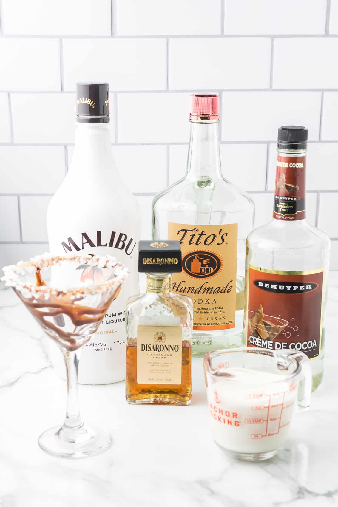 Ingredients to make Almond Joy Martini including, vodka, rum, cream and more.