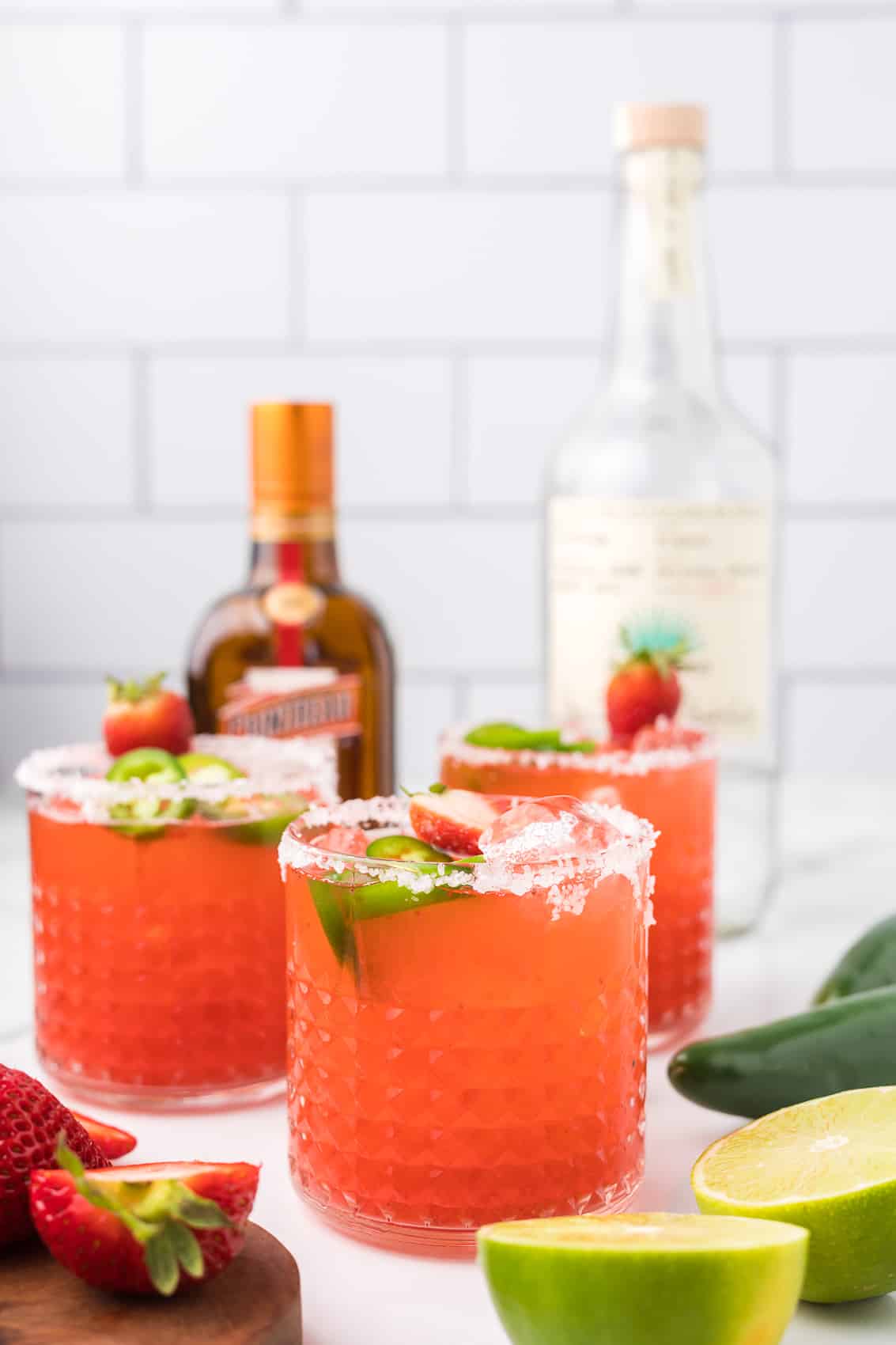 Strawberry Jalapeno Margarita with strawberries, lime and jalapeno as garnish.