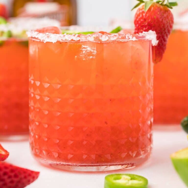 Strawberry margarita with salt and a strawberry as garnish.