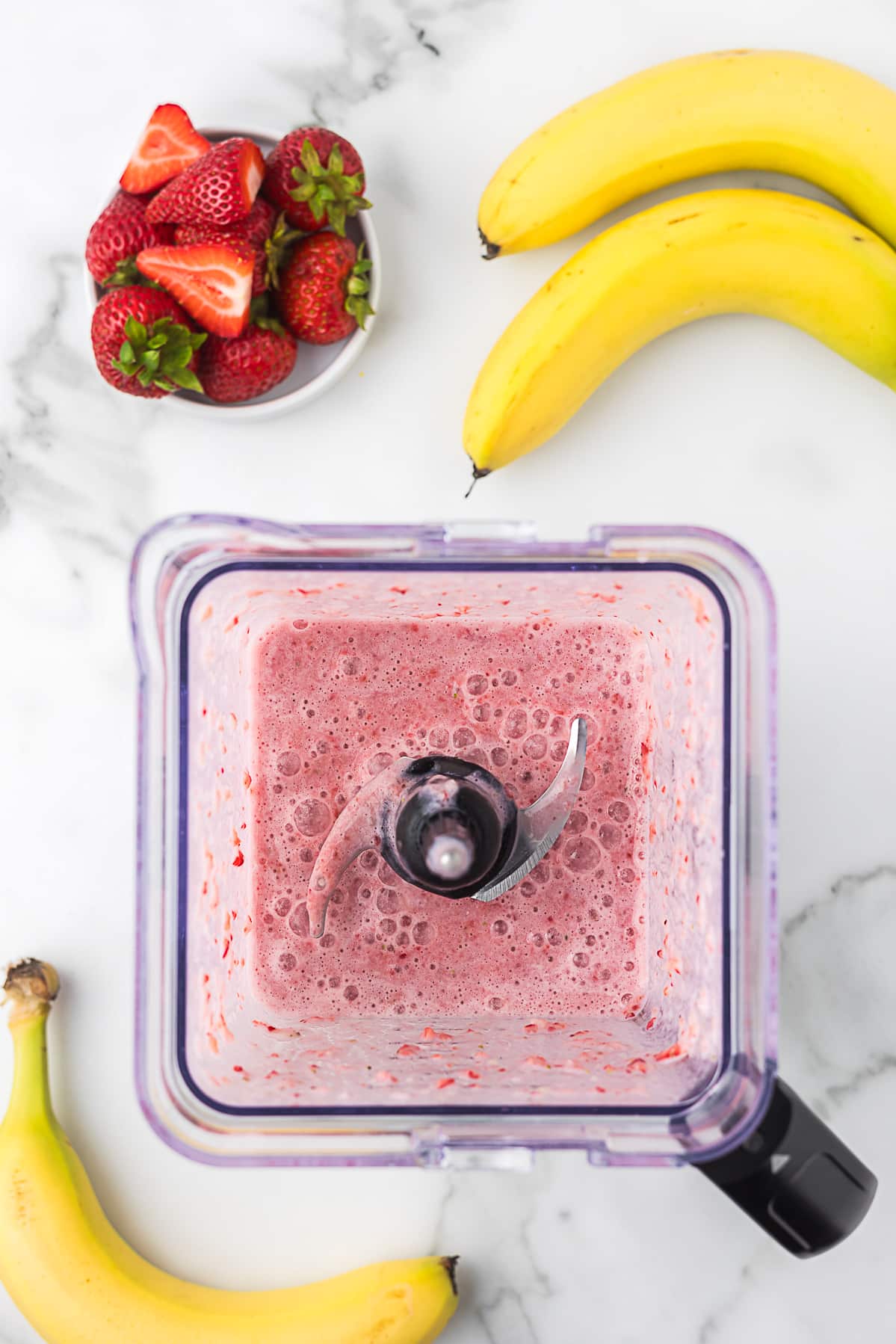 Strawberries, banana and milk after blending to make a strawberry banana smoothie without yogurt.