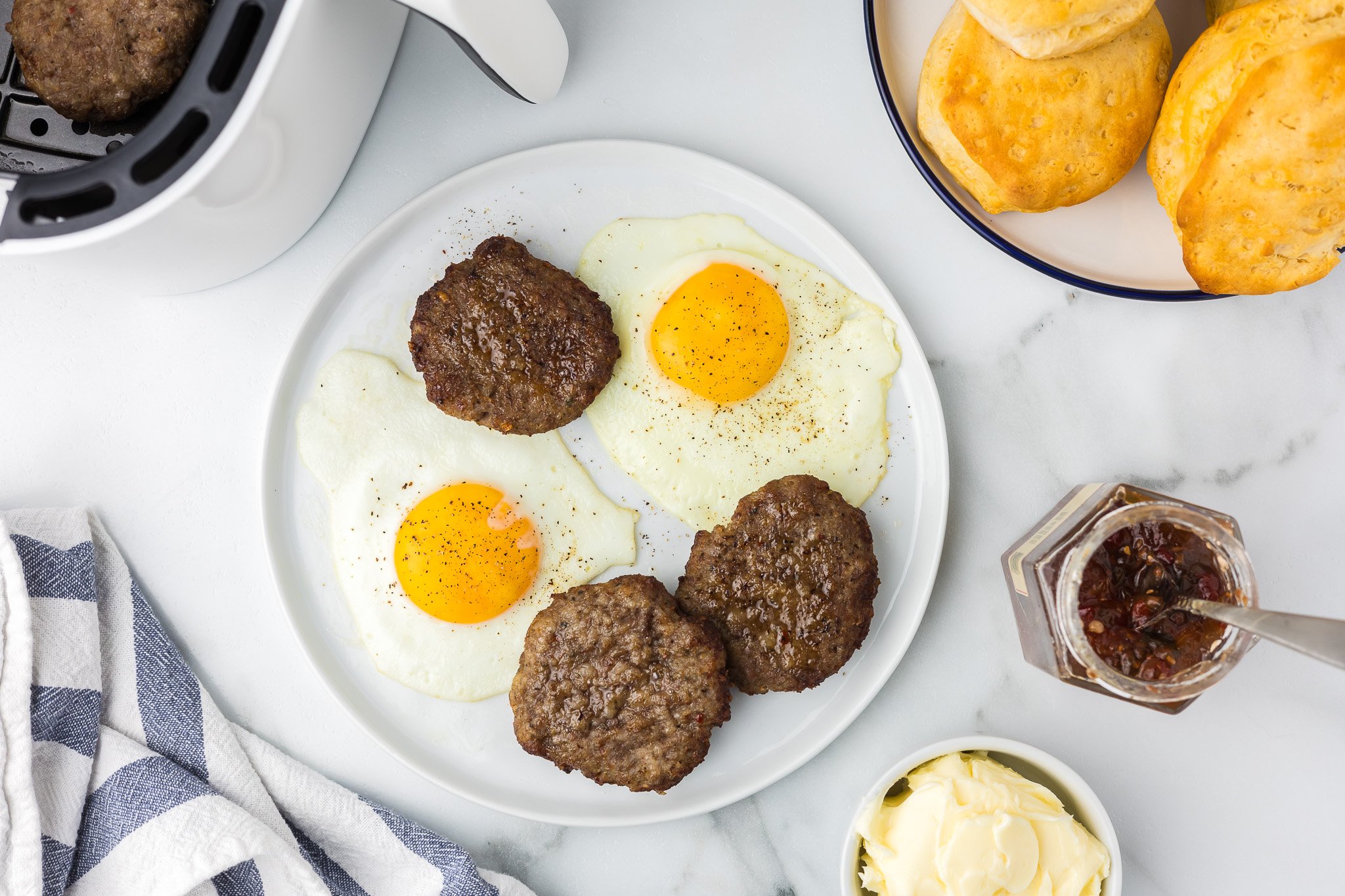 Air Fryer Breakfast Sausage Patties on a plate with eggs.