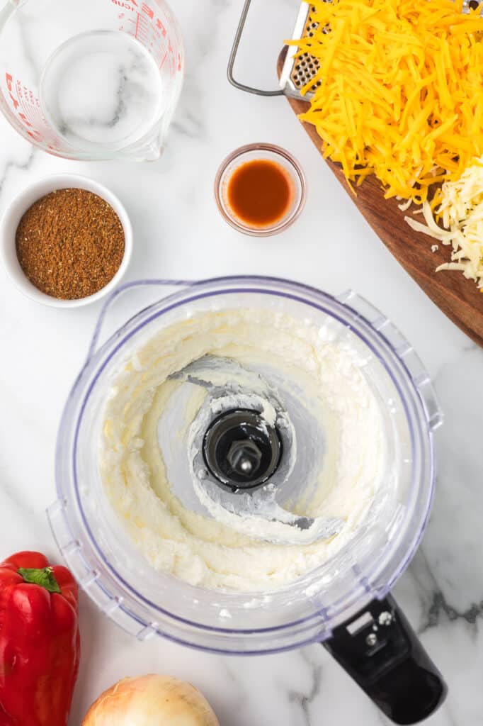 Cottage cheese and cream cheese blended together in a food processor bowl.