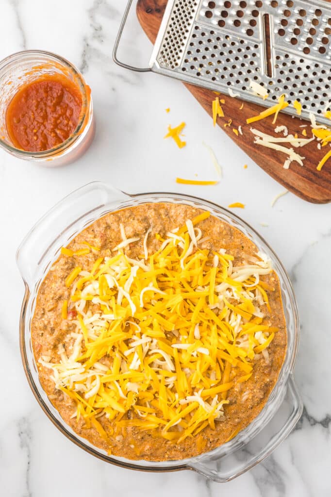 Taco dip with cheese before it is baked.