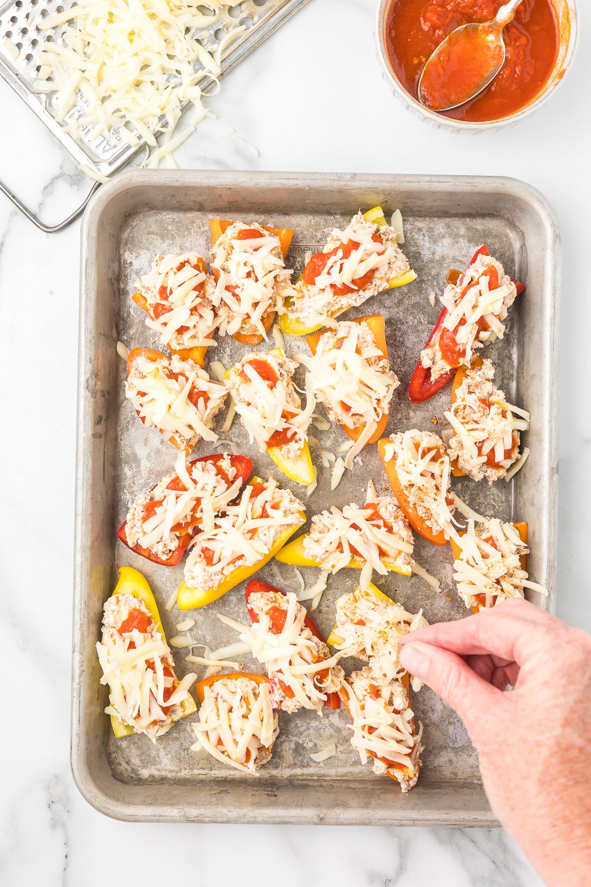 Mini peppers stuffed with Italian sausage and cream cheese then topped with marinara and mozzarella cheese before baking in the oven.