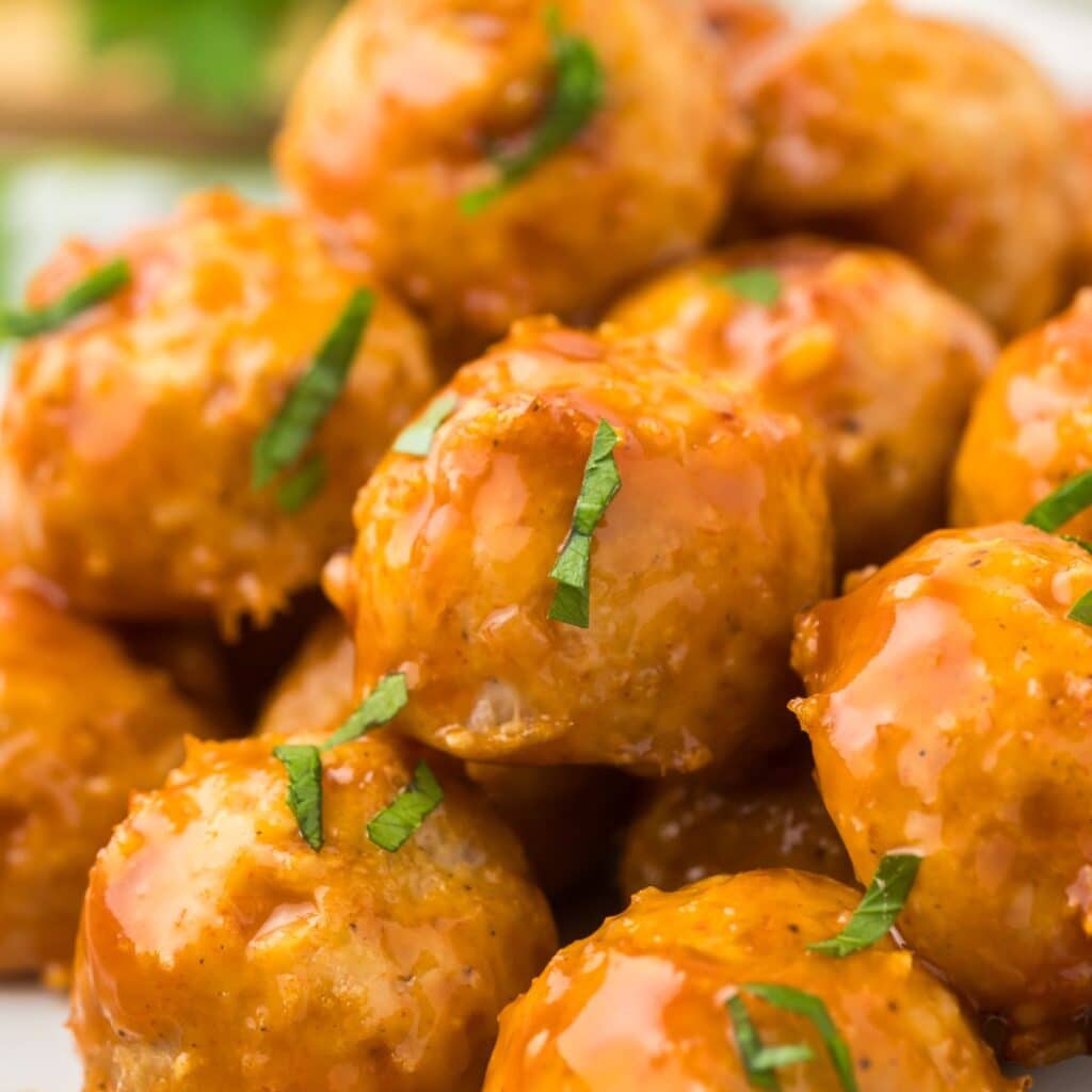Honey Bourbon Meatballs on a plate with chopped parsley as garnish.