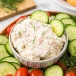 Cream Cheese Cucumber Dip in a bowl with cucumbers and tomatoes around it with fresh dill.