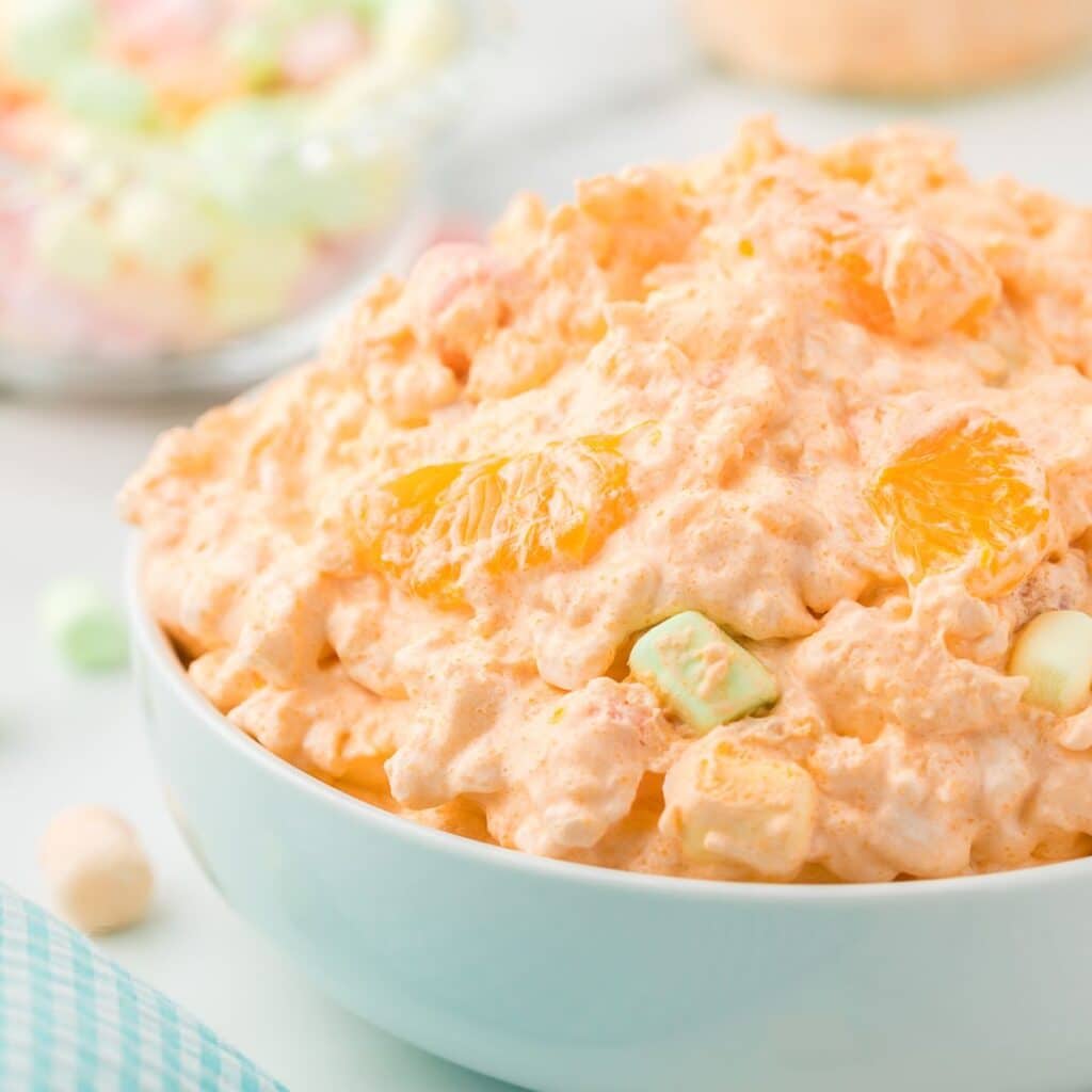 Mandarin orange salad with marshmallows in a white bowl.