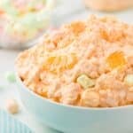 Mandarin orange salad with marshmallows in a white bowl.