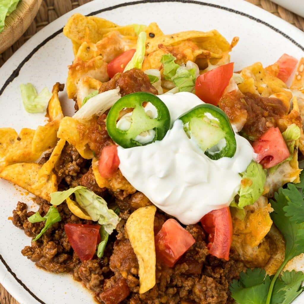 Walking Taco Bake with sour cream, tomatoes and lettuce.