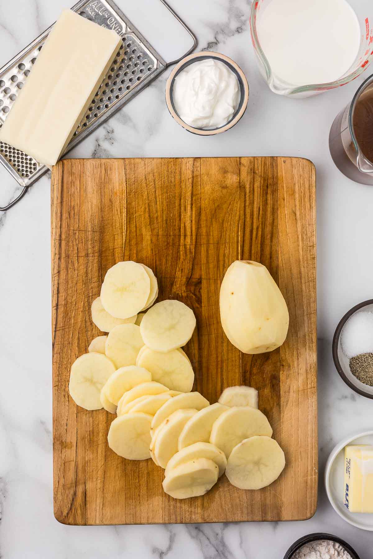 Potatoes sliced on a cutting board.