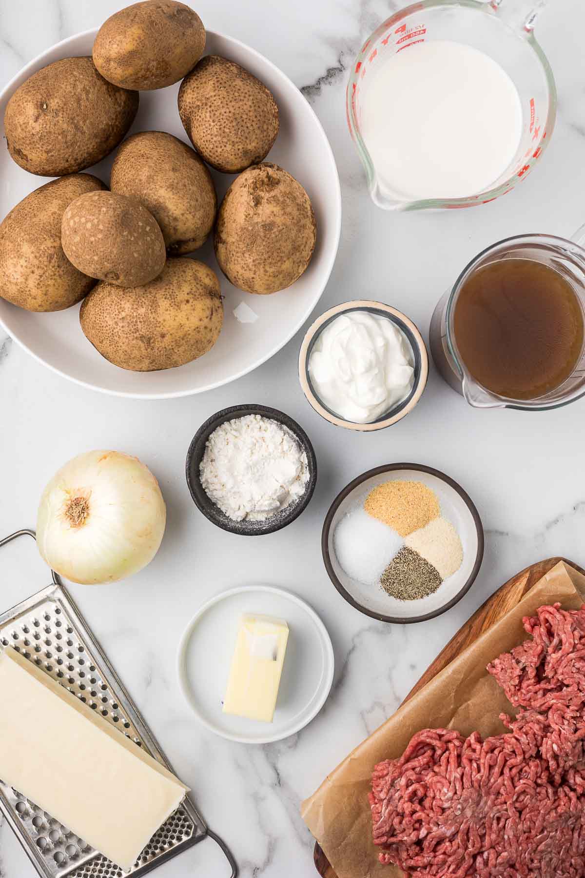 Ingredients to make Potato Stroganoff including potatoes, ground beef and cheese.