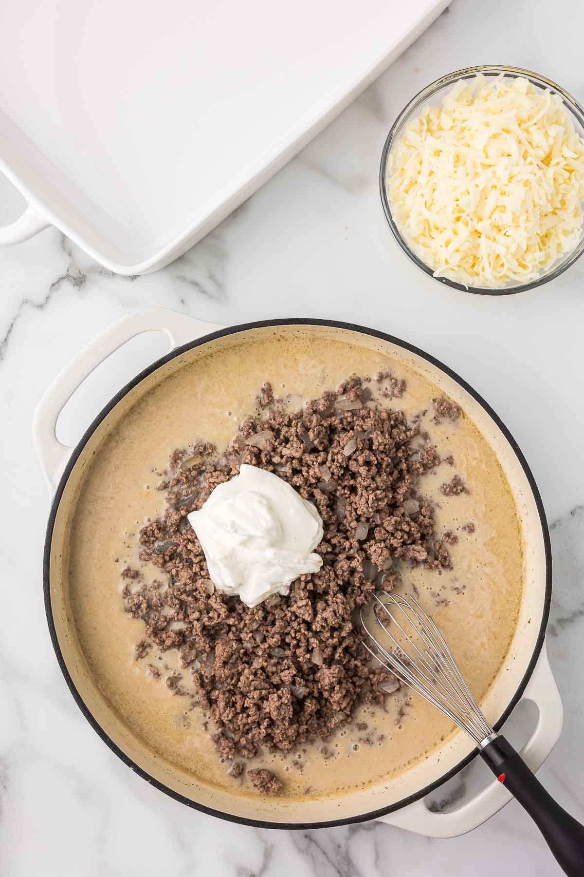 Sauce with ground beef and sour cream being added to make hamburger potato stroganoff.