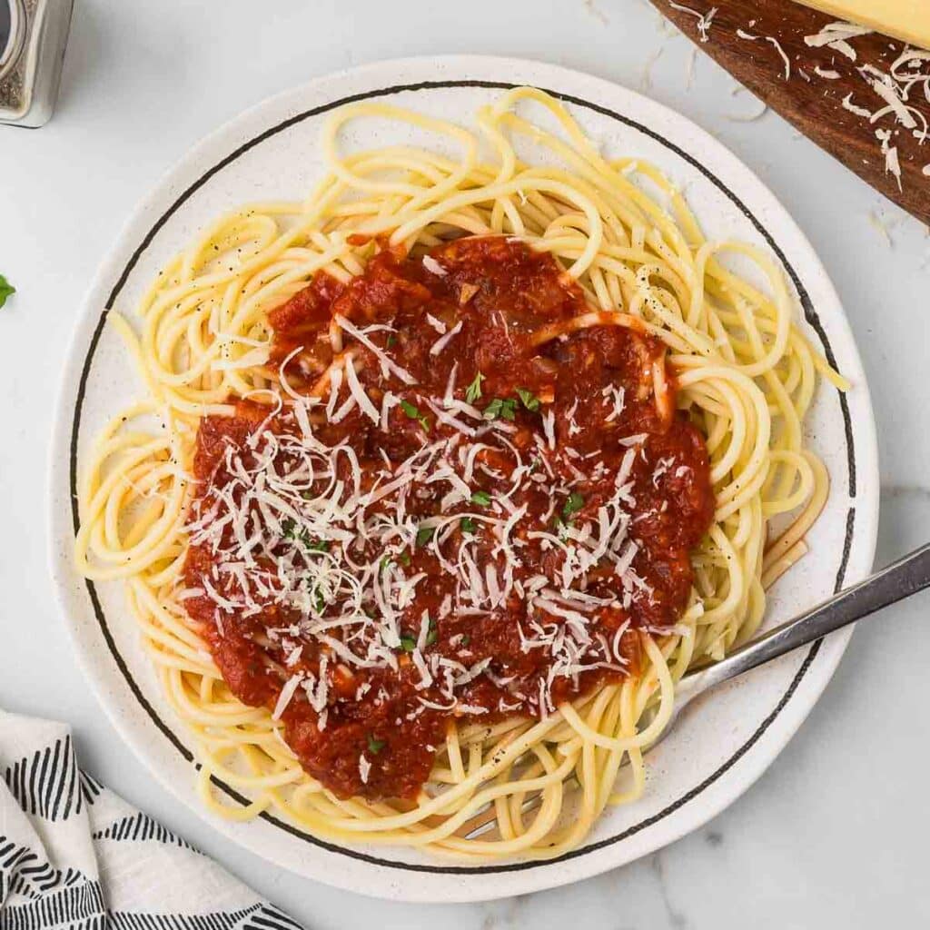 Spicy Spaghetti Arrabbiata pasta dish on a white plate with a fork.