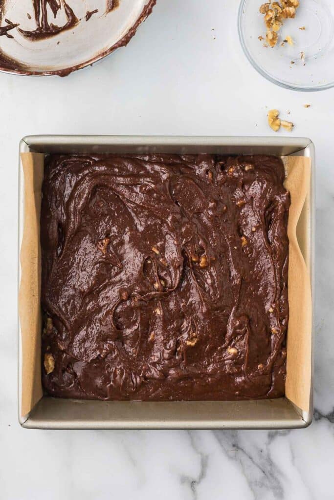 Brownie batter in an 8" square baking pan.