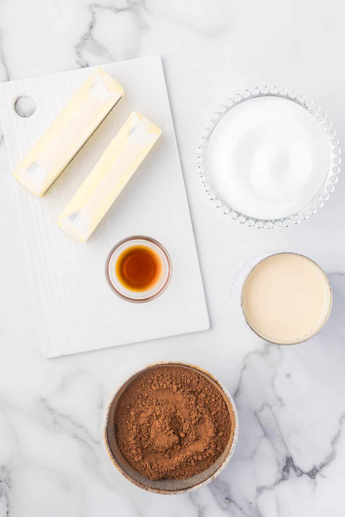 Ingredients to make hot fudge sauce including butter, sugar, cocoa, evaporated milk and vanilla.