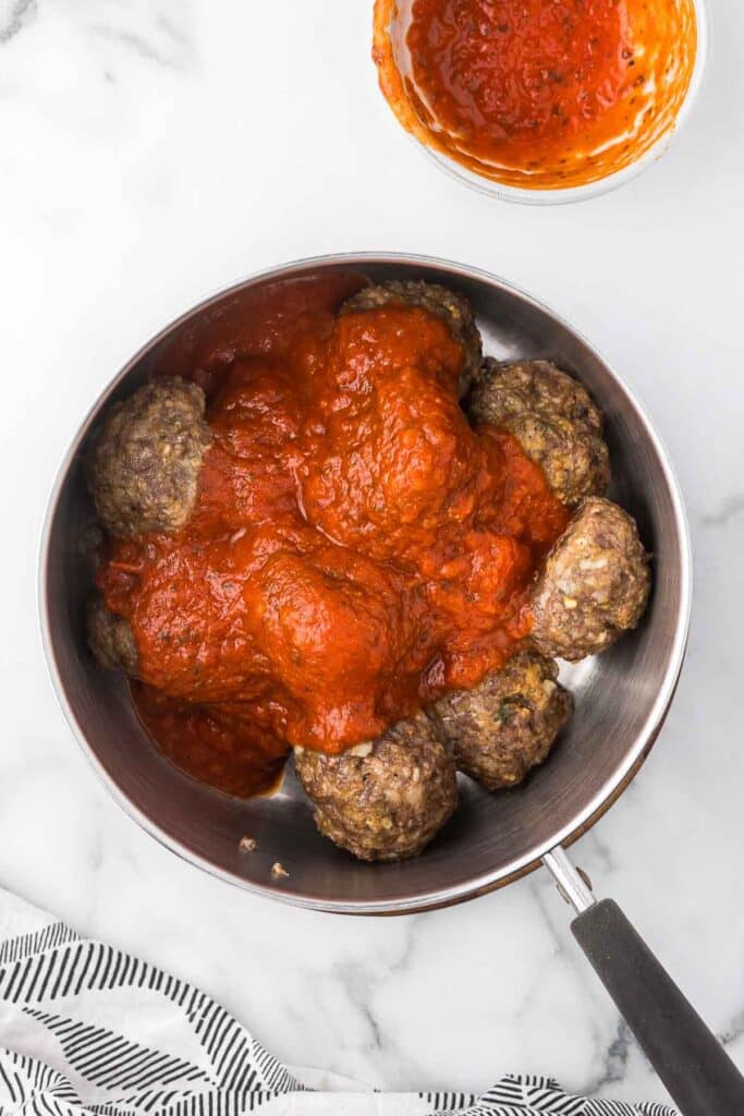 Meatballs in a sauce pan with marinara.