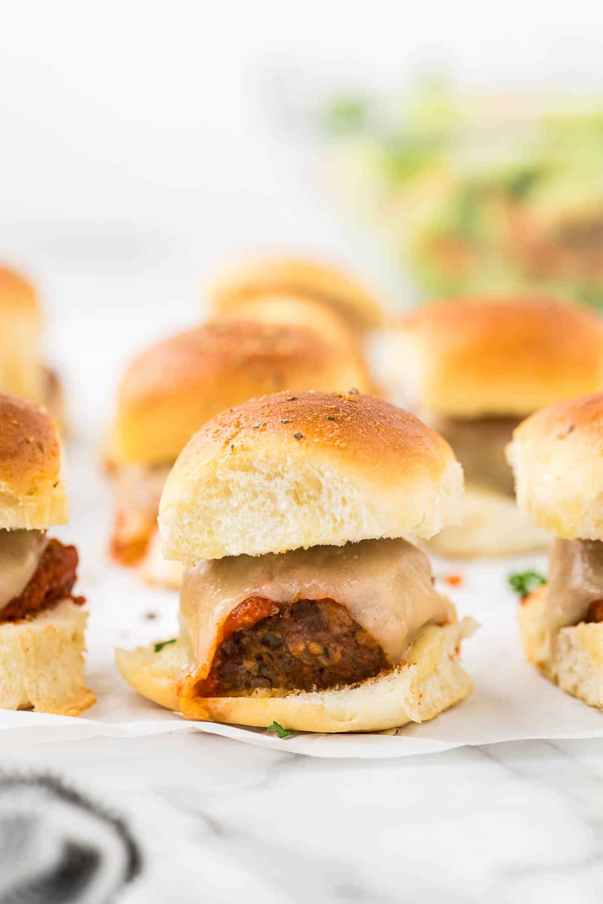 Meatball sliders on parchment paper.