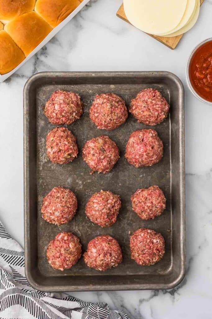 Meatballs on a sheet pan before baking.