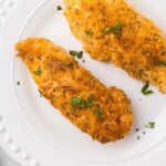 Chicken tenders coated in breadcrumbs with parsley on top.