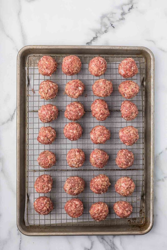 Meatballs before cooking on a sheet pan.