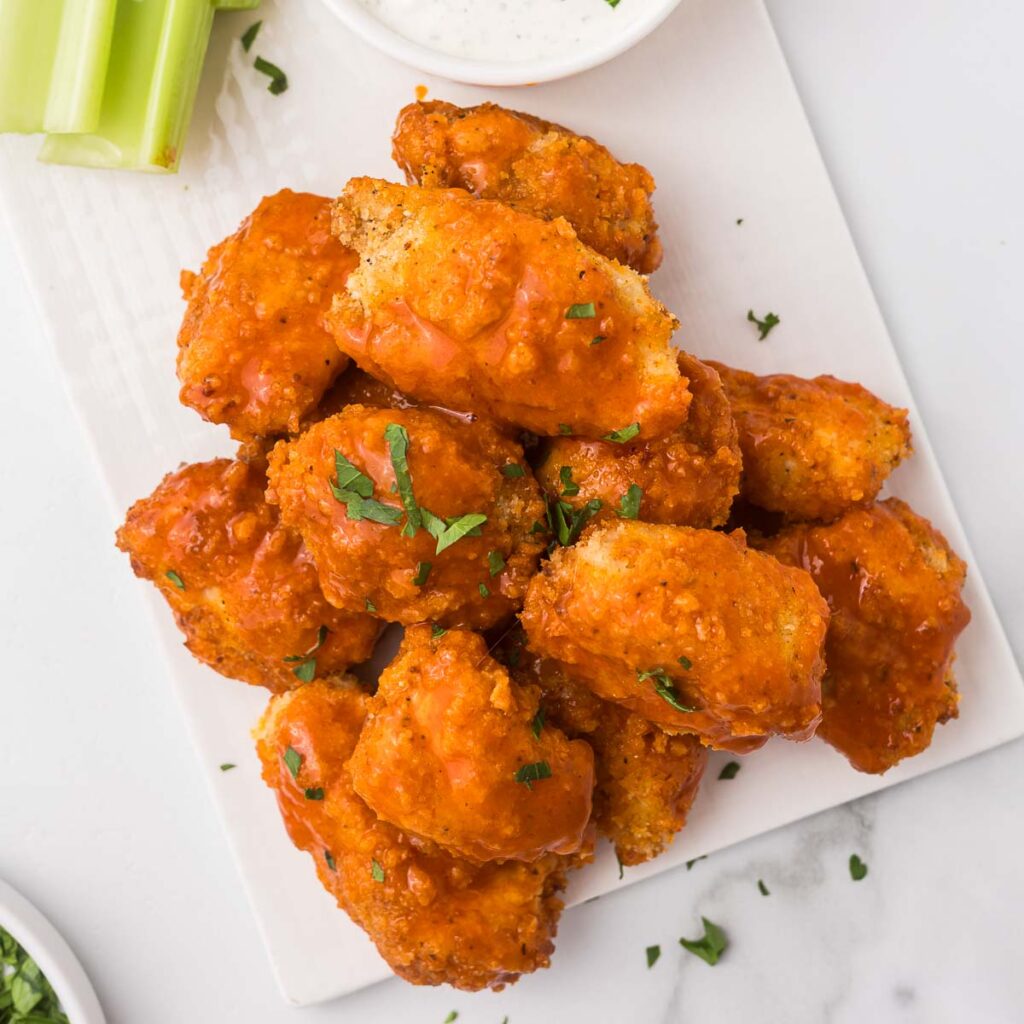 Boneless chicken wings on a plate with celery and ranch dip.