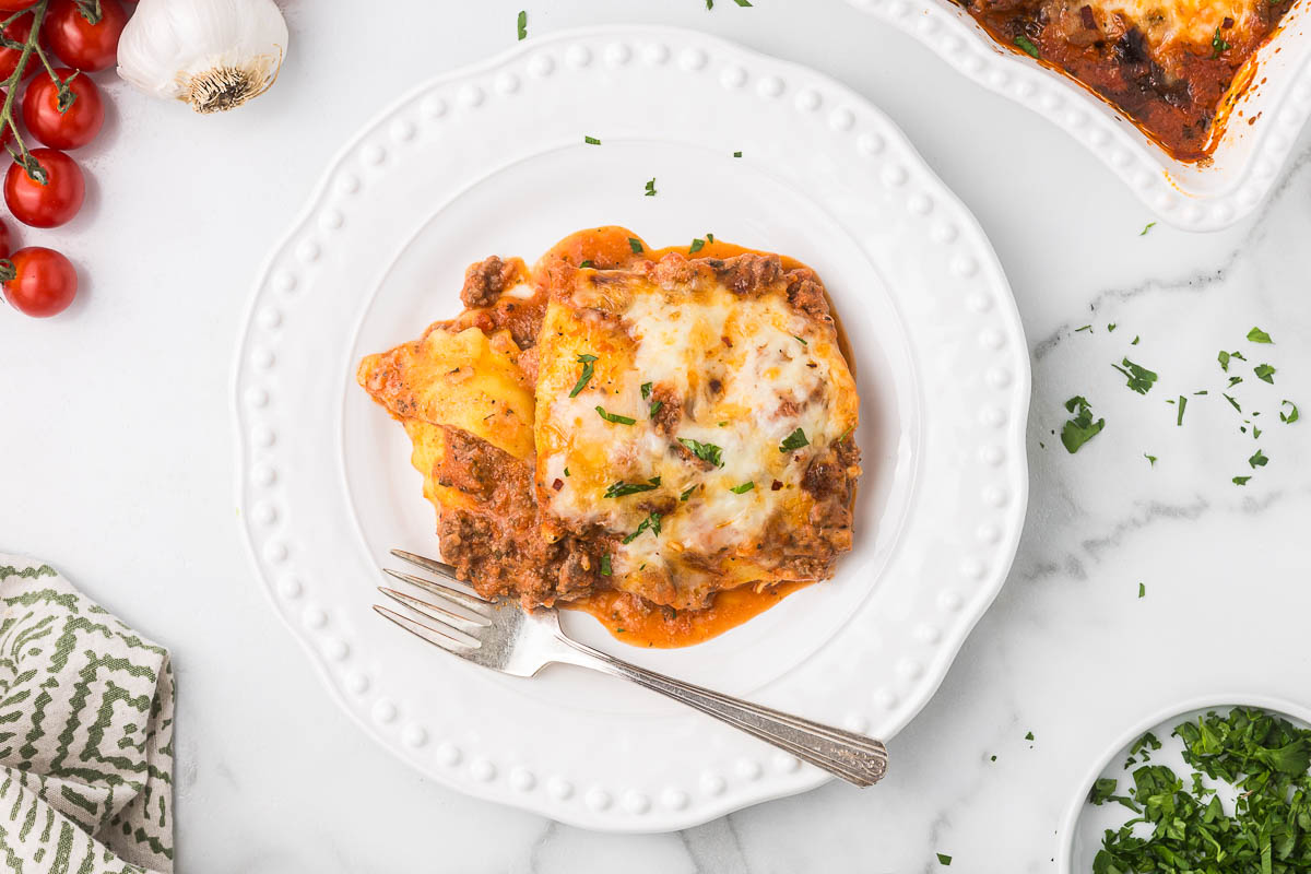 Cheese ravioli casserole on a white plate with a fork.