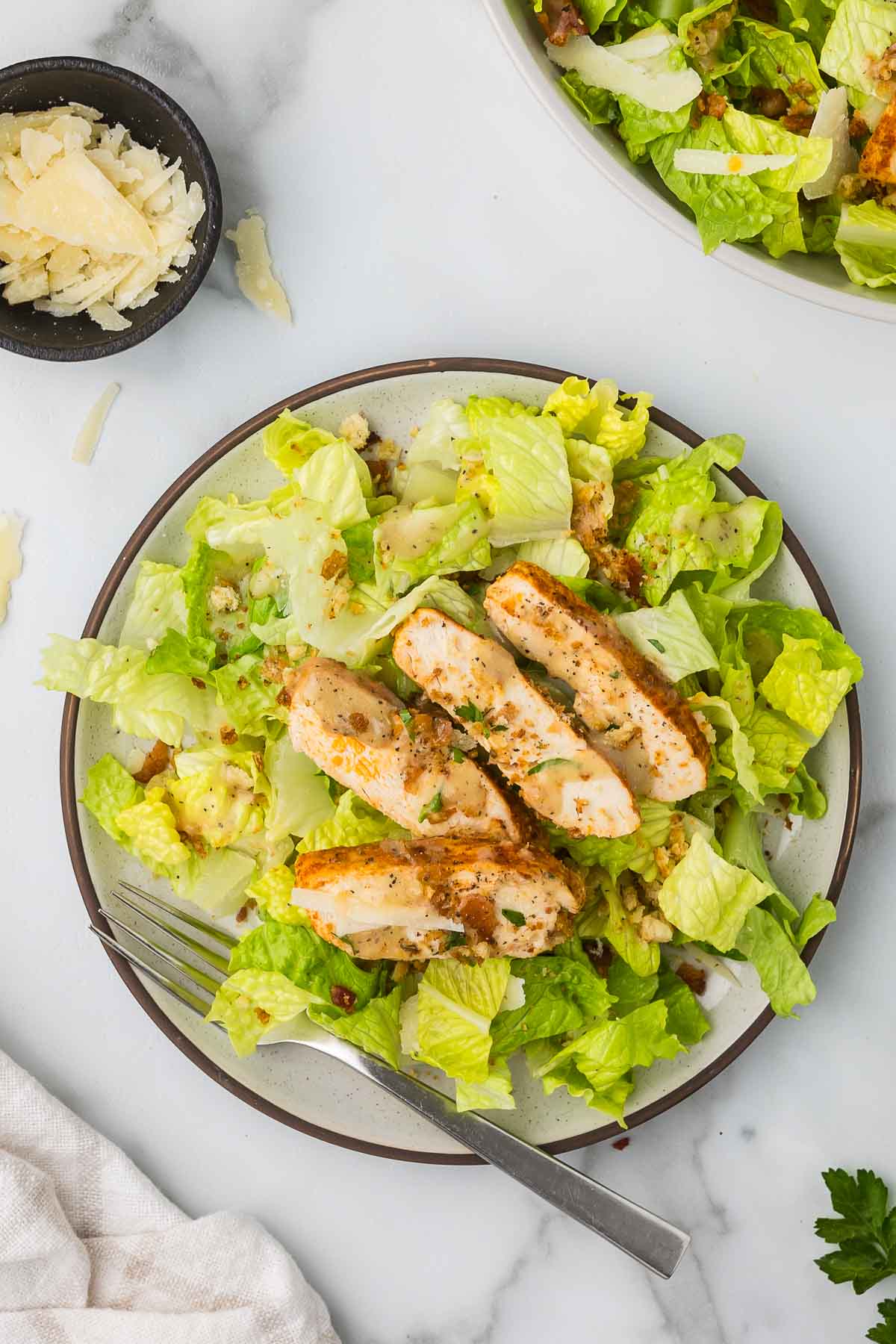 Crispy chicken caesar salad on a plate brown rimmed salad plate.