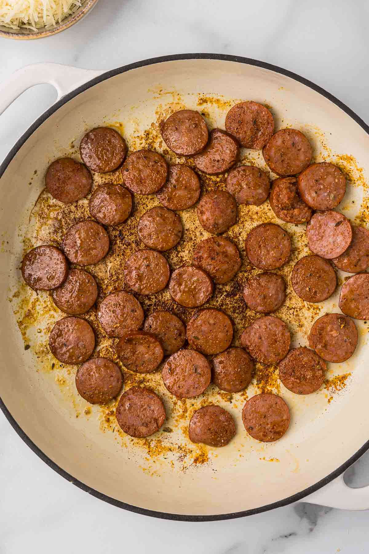 Spicy andouille sausage in a pan searing.