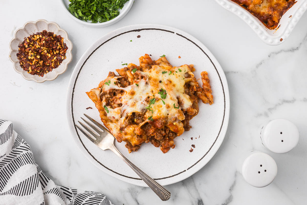 Lasagna Casserole on a plate with parsley and red pepper flakes.