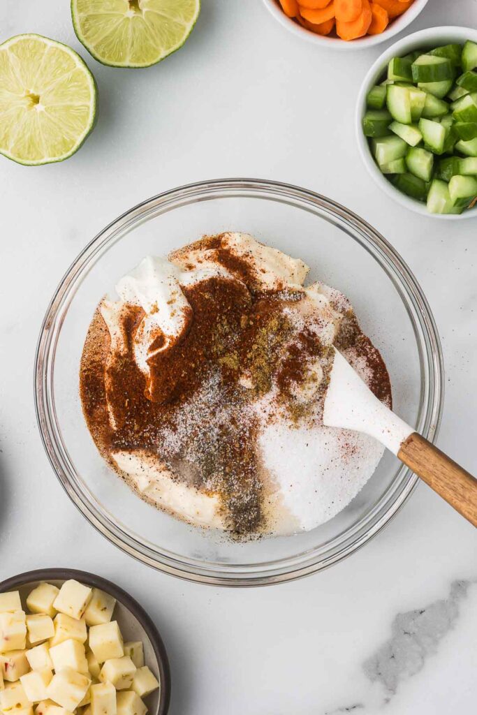 Mayonnaise, lime, sour cream and spices in a bowl to create the sauce for Mexican Macaroni Salad.