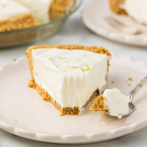 Key lime pie on a plate with one piece missing.