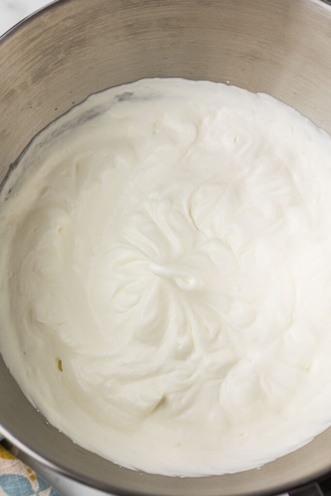 Whipped cream in a mixing bowl when ready to add to the key lime pie.