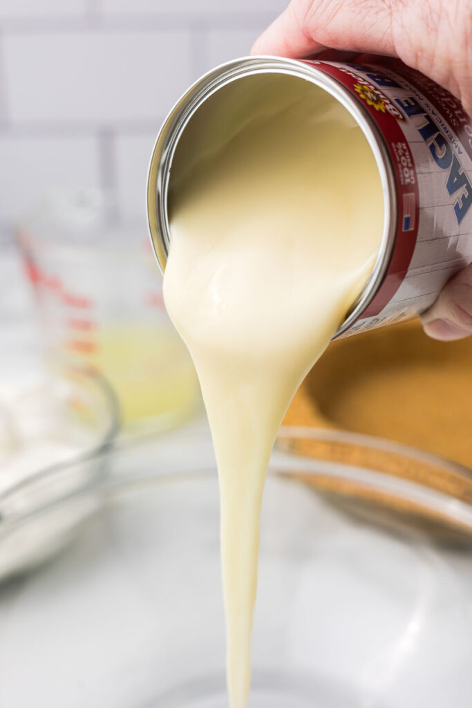 Sweet condensed milk being poured out of the can.