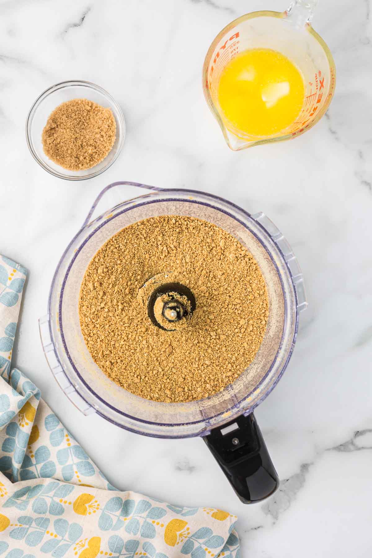 Graham crackers in a food processor after being crushed.