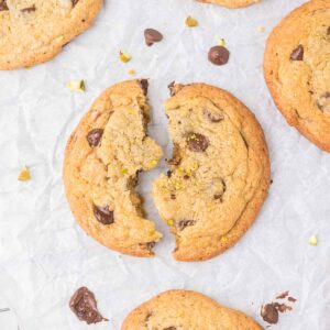 Pistachio Chocolate Chip Cookie in half on parchment paper.