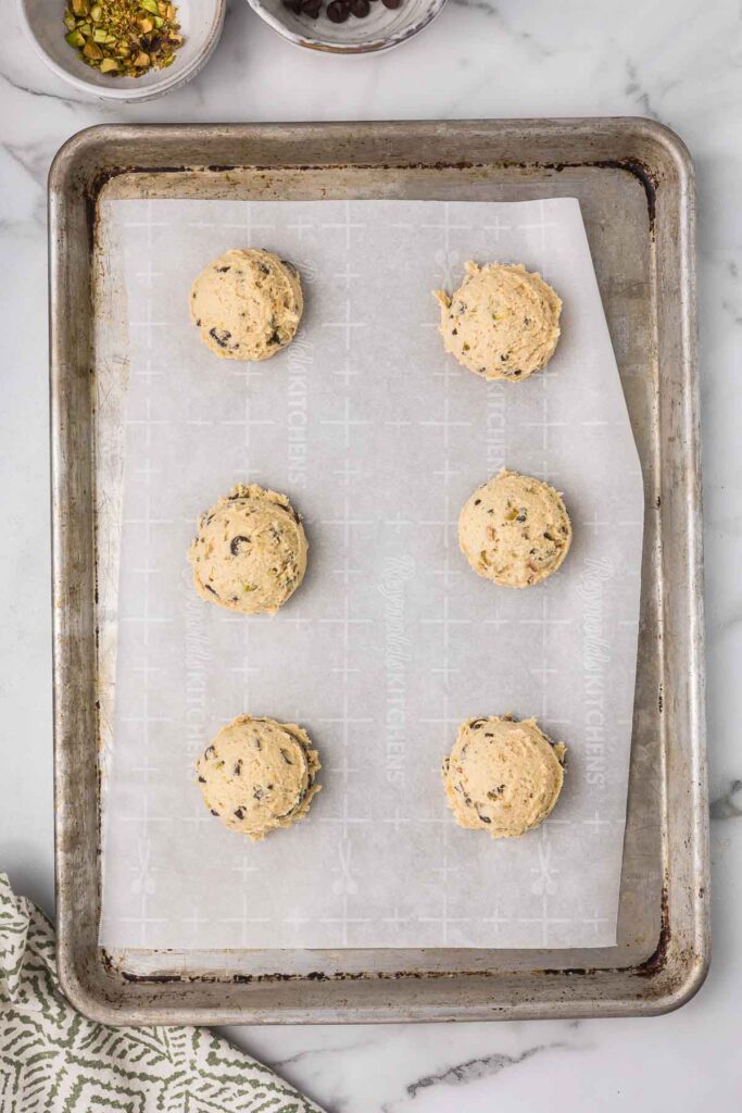 Cookie dough in balls on a cookie sheet before baking.