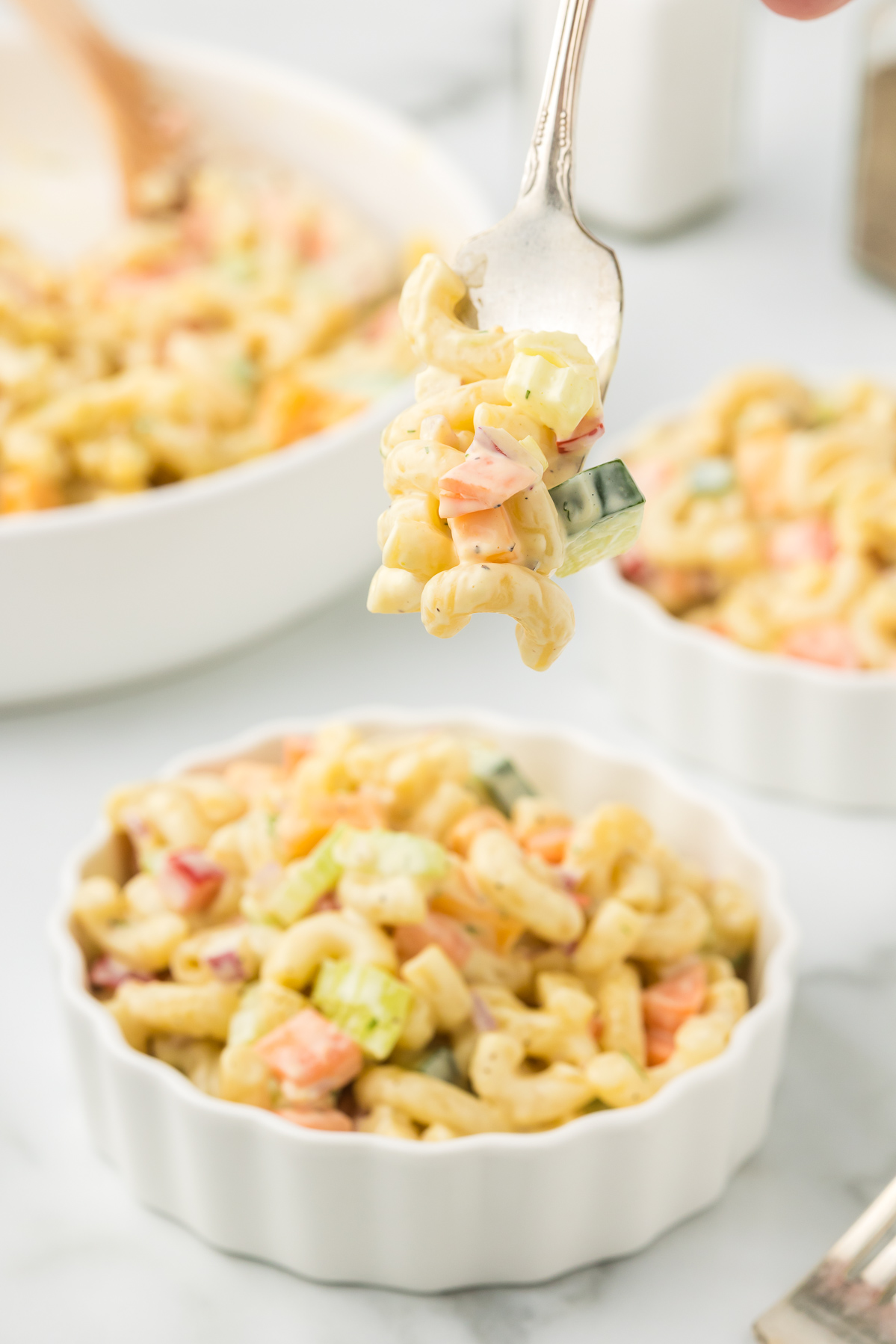 Pasta salad with vegetables on a fork.