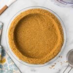Homemade no bake graham cracker crust in a glass pie pan.
