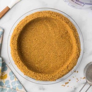 Homemade no bake graham cracker crust in a glass pie pan.