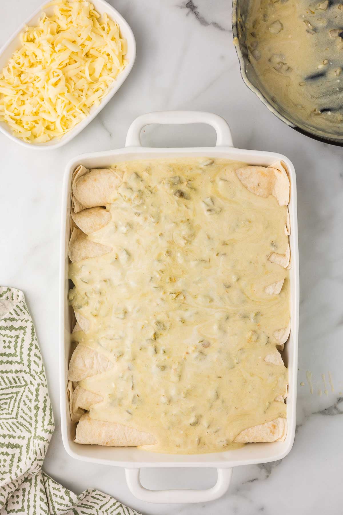 Chicken enchiladas covered with green chile sour cream sauce.